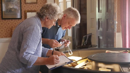 Two volunteers are inspecting some of the items on display at Berrington Hall, Herefordshire.